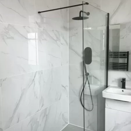 Carrara effect gloss porcelain wall and floor tiles in a bathroom setting.