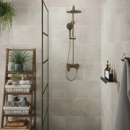 bloomberg gloss wall tile limestone effect tiled in a bathroom with brass shower and shower screen.