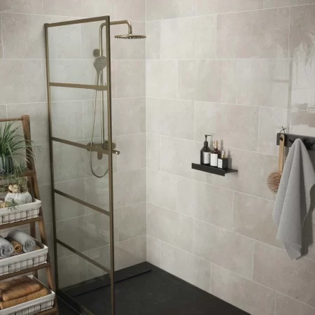 bloomberg gloss wall tile limestone effect tiled in a bathroom with brass shower and shower screen.