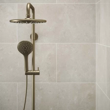 bloomberg gloss wall tile limestone effect tiled in a bathroom with brass shower and shower screen.