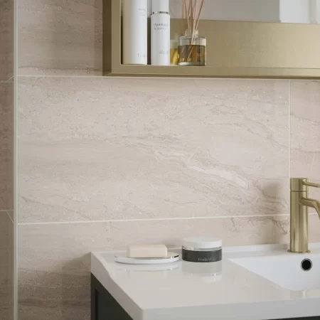 laurent beige 300x600mm ceramic wall tile in a bathroom with gold fixtures.