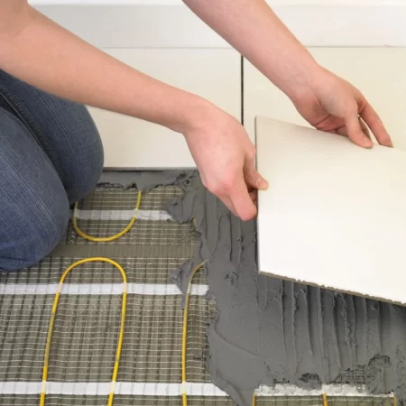 image of an installer laying electric underfloor heating mat 150w