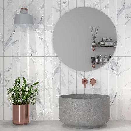 marble grey tile on a bathroom wall with a grey sink and a round mirror.